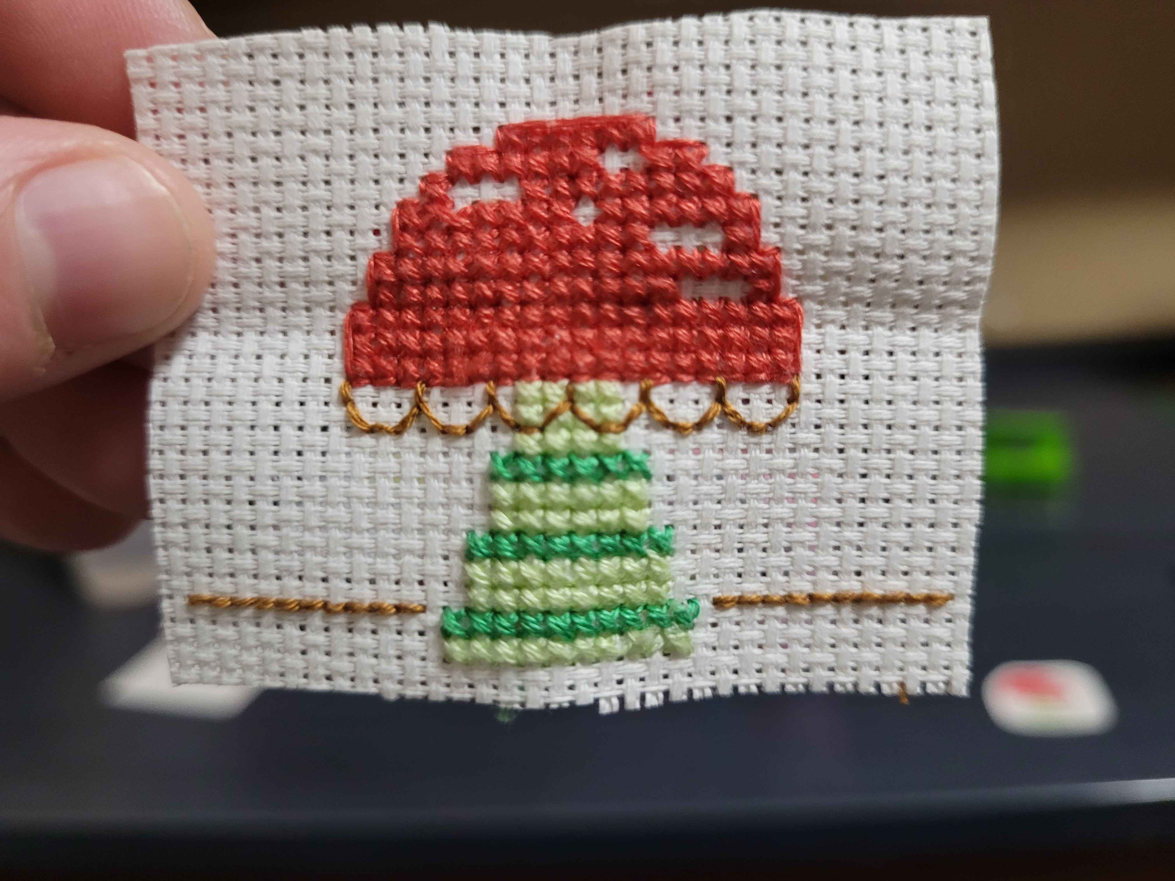 A crude red cross stitch mushroom